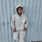 Child wearing a beige The Minis hoodie and matching sweatpants set, standing casually against a wall.